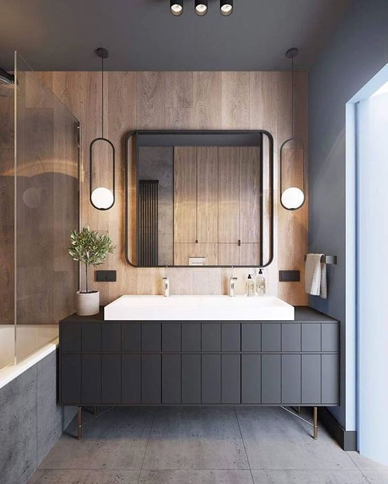 Zdjęcie łazienki z szarą szafką i ścianą w kolorze drewna