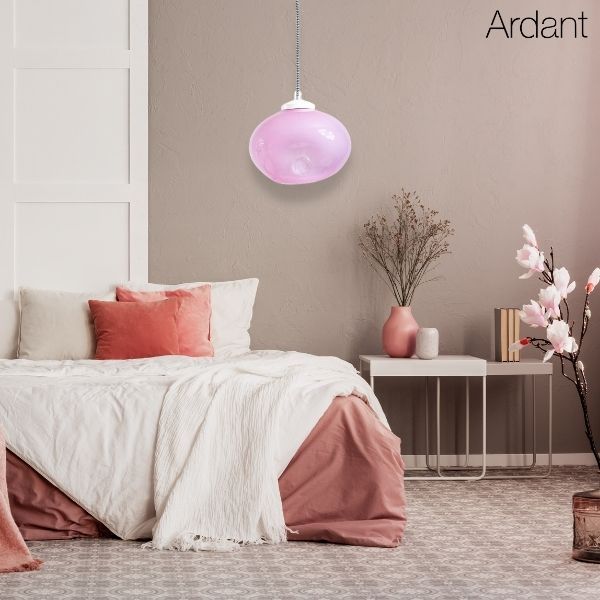 Lampa wisząca z różowym kloszem nad łóżkiem