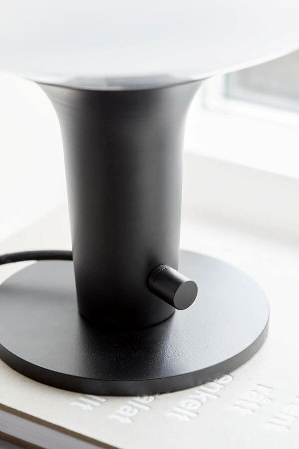 minimalistyczna lampa stołowa z mlecznym kloszem i czarną podstawą