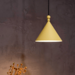 musztardowa lampa wisząca do betonowej ściany