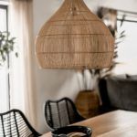 duża rattanowa lampa nad drewniany stół