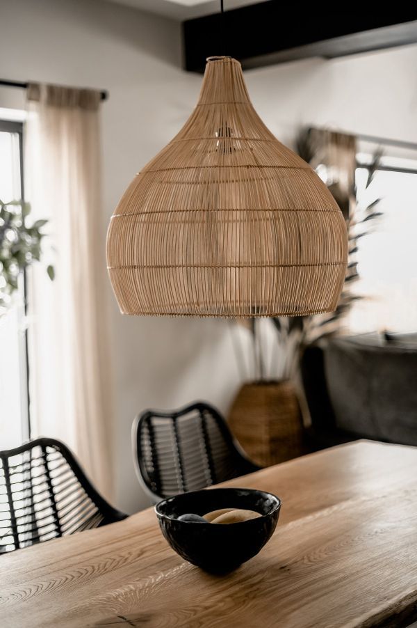 duża rattanowa lampa nad drewniany stół