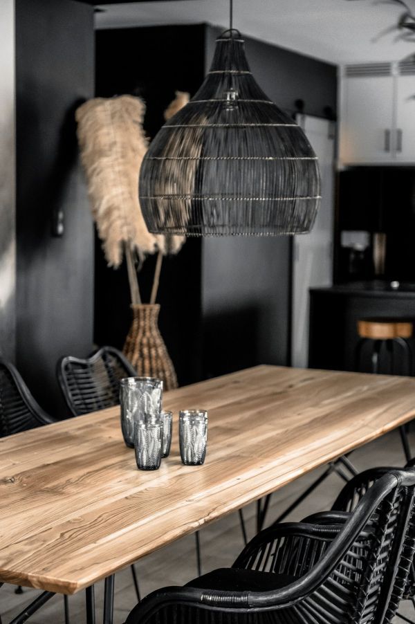 czarna lampa wisząca nad stołem z drewna