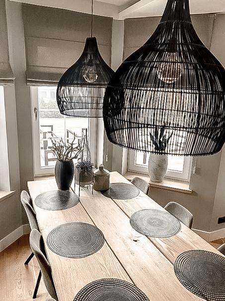 czarna lampa wisząca nad surowy drewniany stół