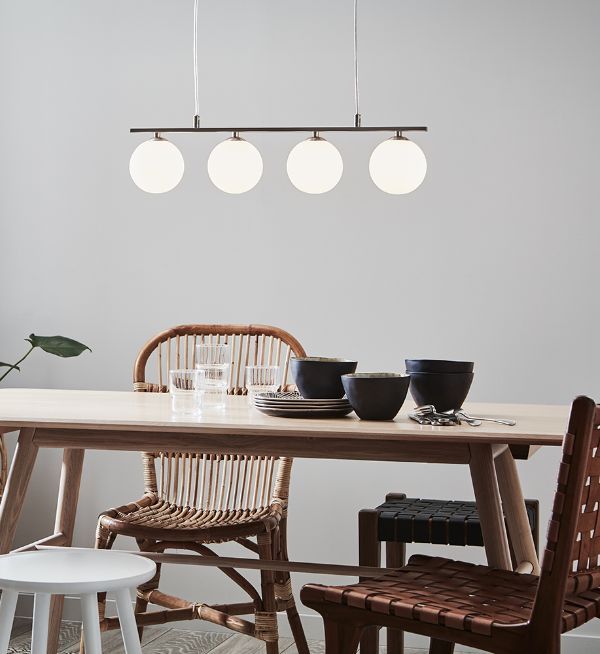 biało-czarna lampa wisząca nad drewniany stół