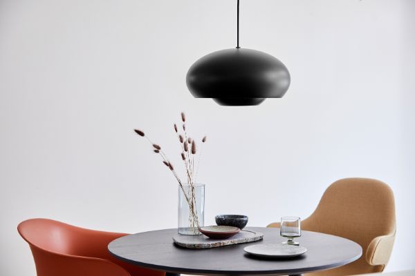 czarna lampa wisząca nad okrągłym stołem
