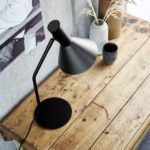 czarna lampa biurkowa na drewnianym blacie