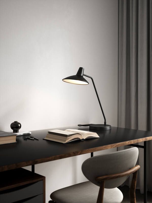 czarna lampa stołowa na szarej ścianie do biura
