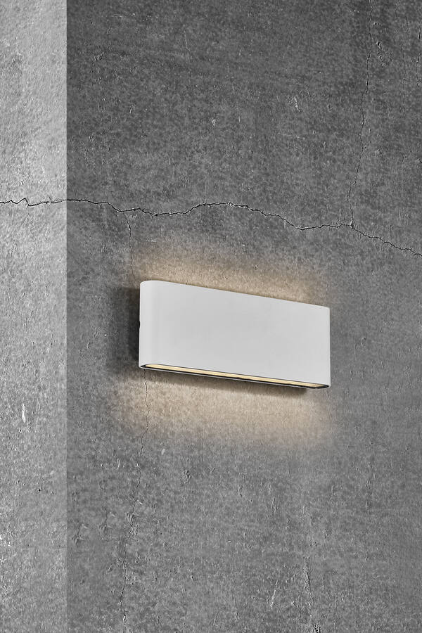 podłużny biały kinkiet na betonowej ścianie