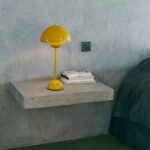 żółta lampa stołowa w szarej sypialni