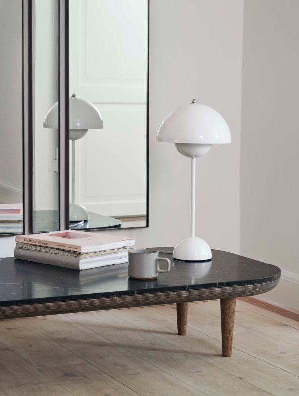 biała lampa stołowa na niskiej konsoli w salonie