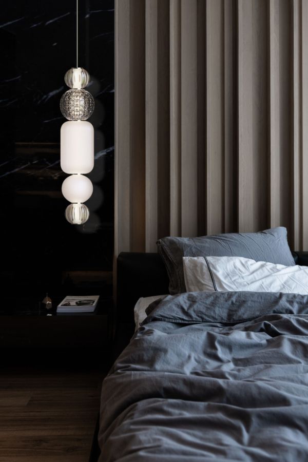 pionowa lampa wisząca do sypialni obok łóżka