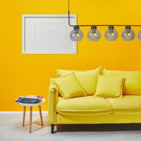 Nowoczesna lampa wisząca nad żółtą sofą