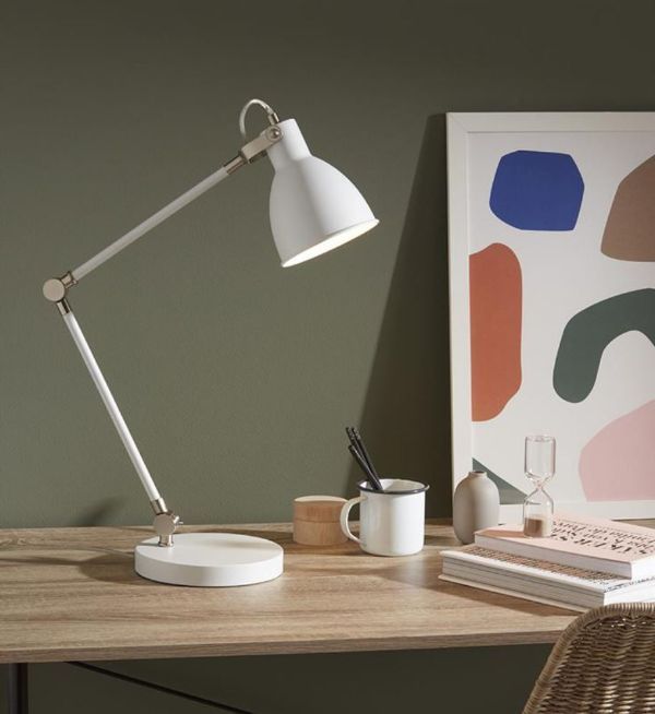 Lampa biurkowa w białym kolorze na drewnianym blacie