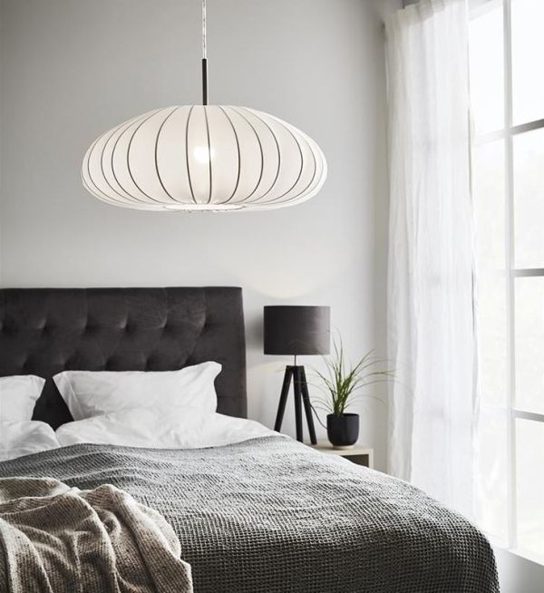 Lampa wisząca nad dużym łóżkiem w sypialni