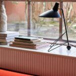 Czarna lampa biurkowa na parapecie przy oknie