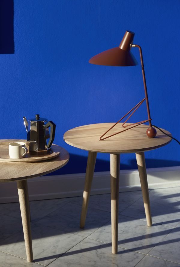 Lampa biurkowa tripod na tle niebieskiej ściany