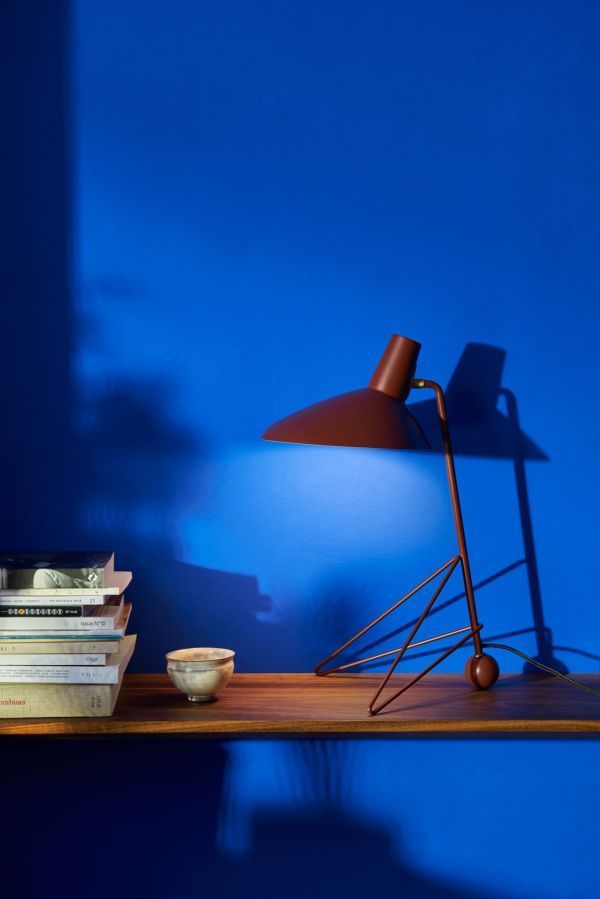 Lampa biurkowa bordowa na tle niebieskiej ściany
