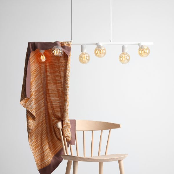 Lampa wisząca z białymi oprawkami i żarówkami nad krzesłem