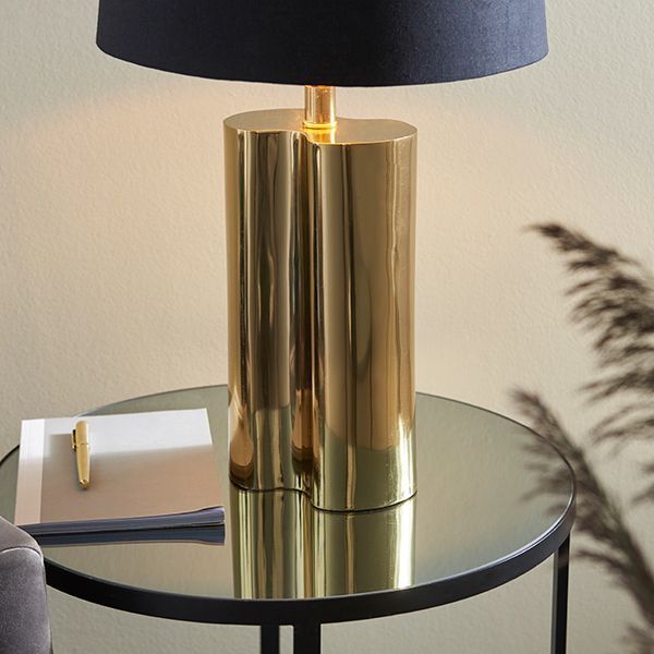 Lampa ze złotą podstawą na stoliku okrągłym