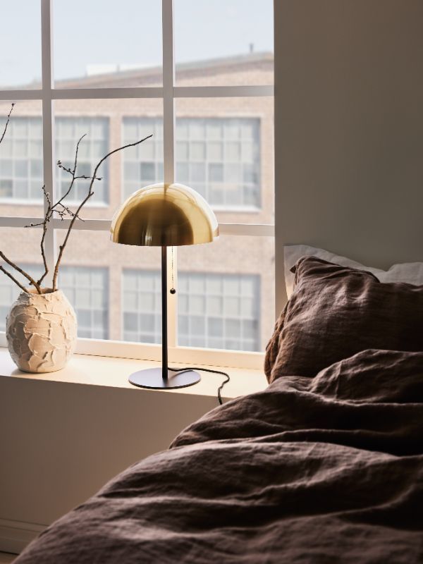 Lampa stołowa na parapecie w eleganckiej sypialni