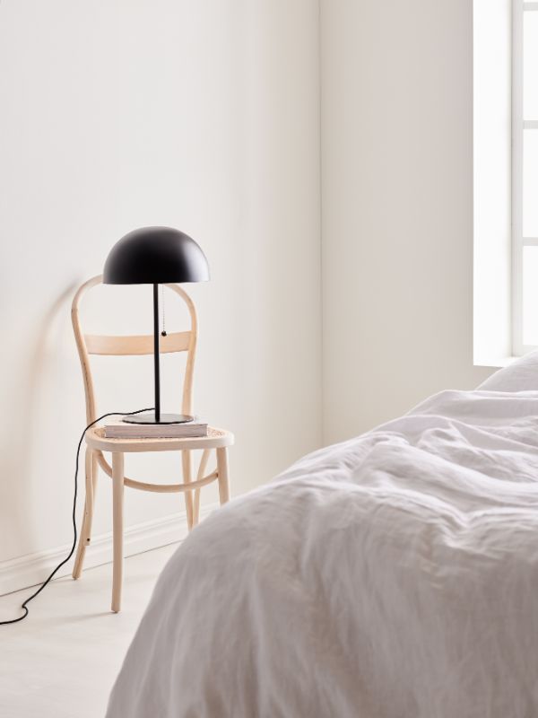 Lampa stołowa na krześle w jasnej sypialni