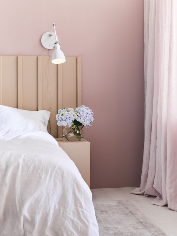 Kinkiet biały na różowej ścianie w sypialni