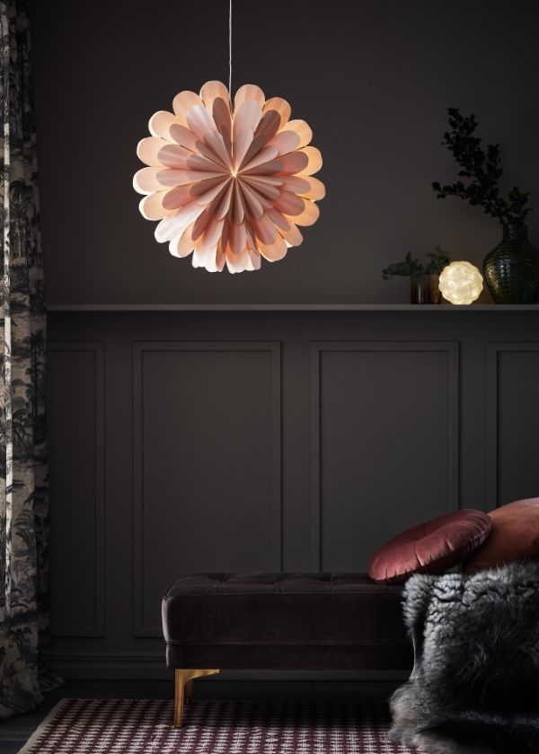 Lampa wisząca w kształcie kwiatu nad sofą