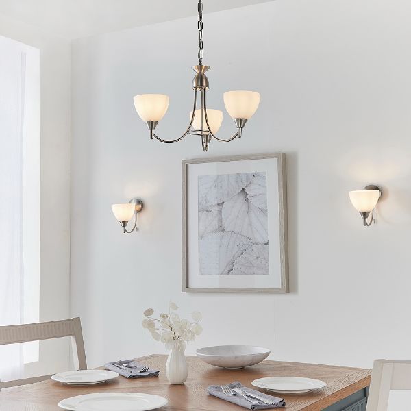 Kolekcja eleganckich lamp nad stołem w jasnej jadalni