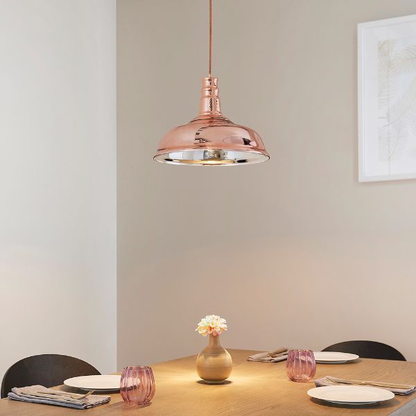 Lampa w kolorze miedzianym nad drewnianym stołem