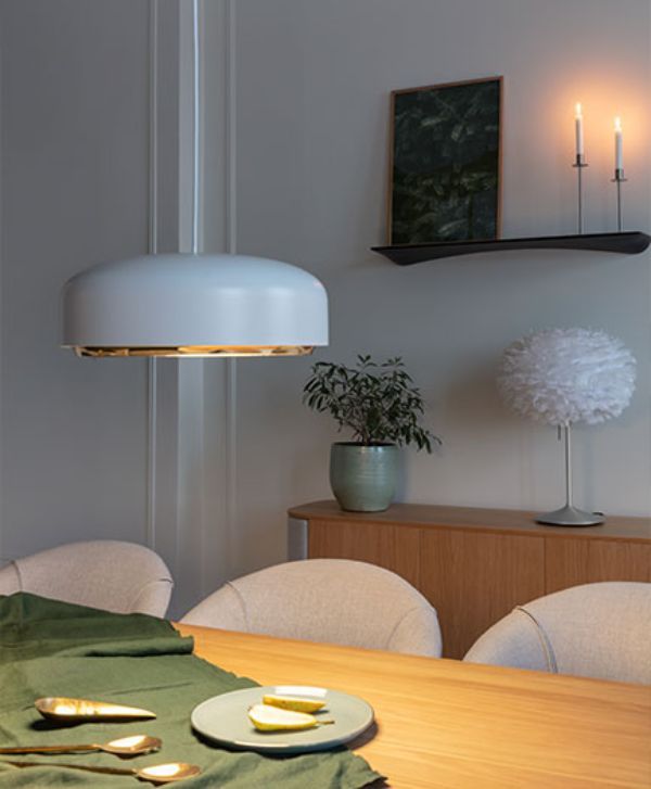 Elegancka lampa wisząca nad stołem drewnianym w jadalni