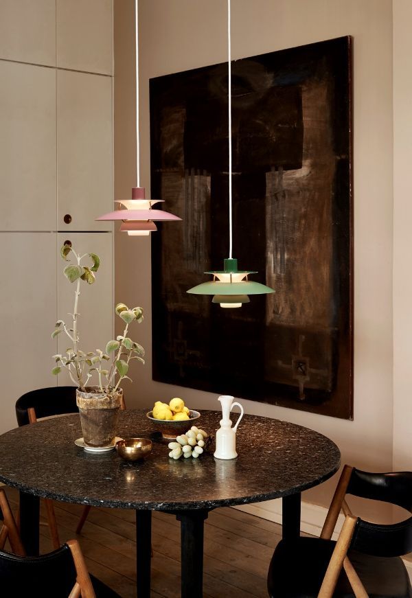 Kolorowe lampy wiszące nad czarnym stołem
