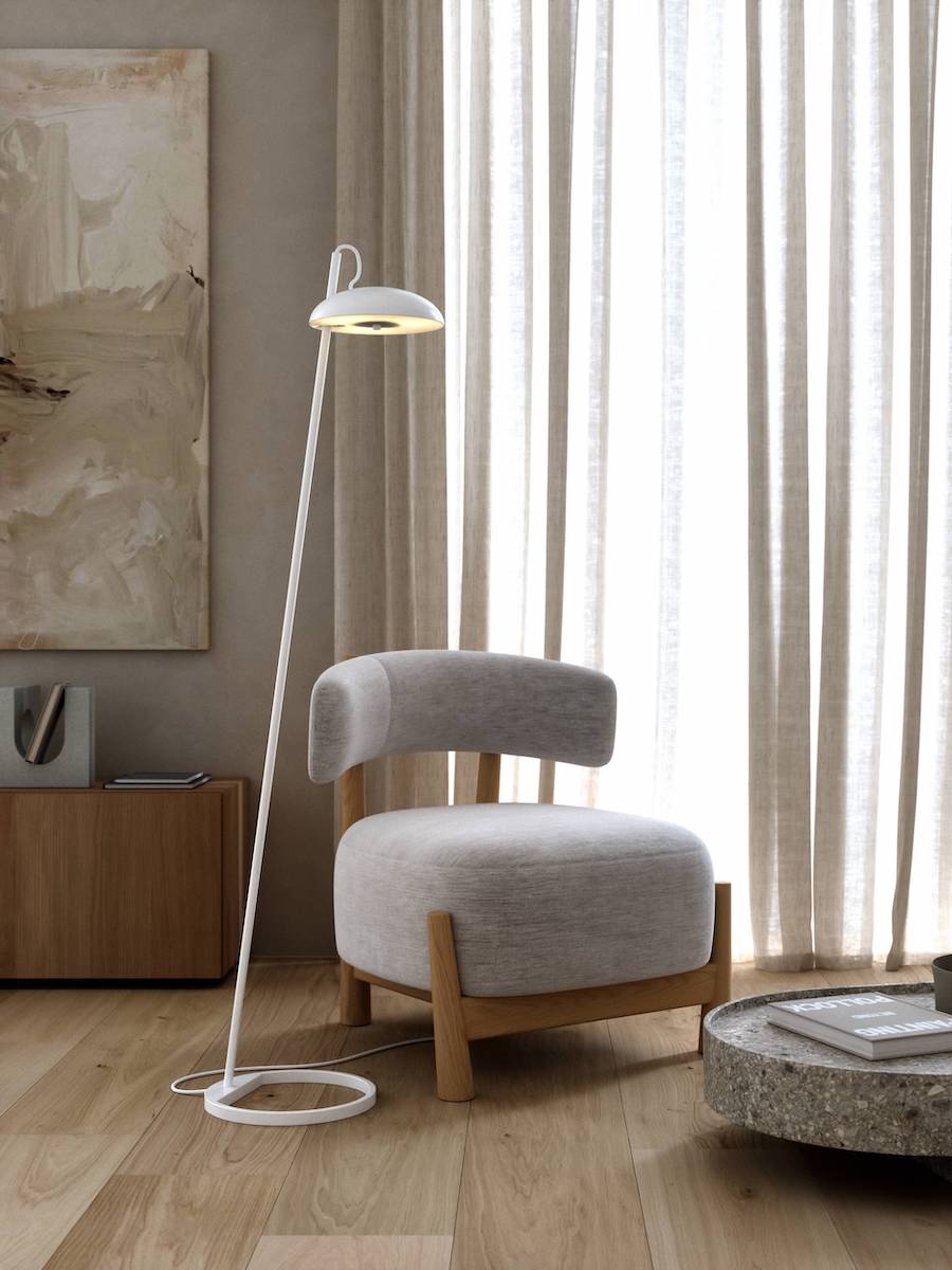Elegancka lampa podłogowa obok fotela w salonie