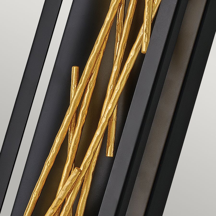 Złote elementy dekoracyjne kinkietu w czarnej obudowie