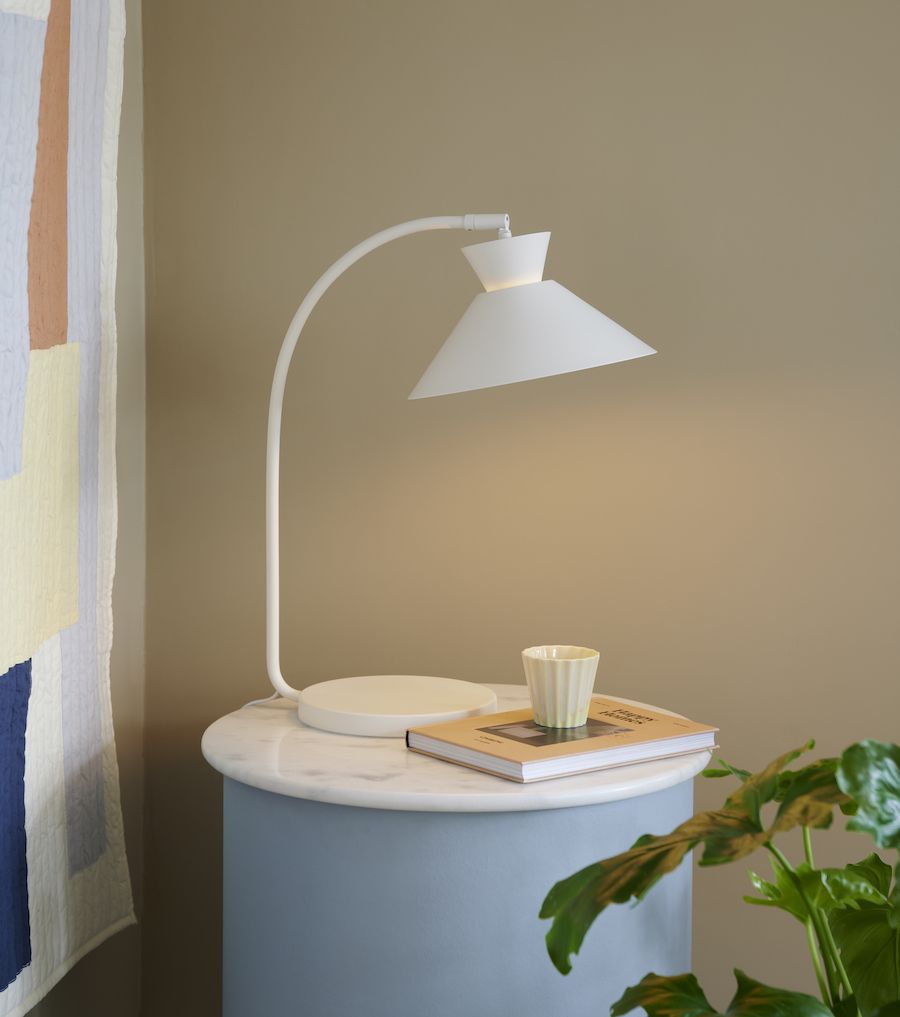 Lampa stołowa w kolorze białym na stoliku w salonie