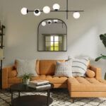 Lampa wisząca z mlecznymi kloszami nad pomarańczową sofą w salonie