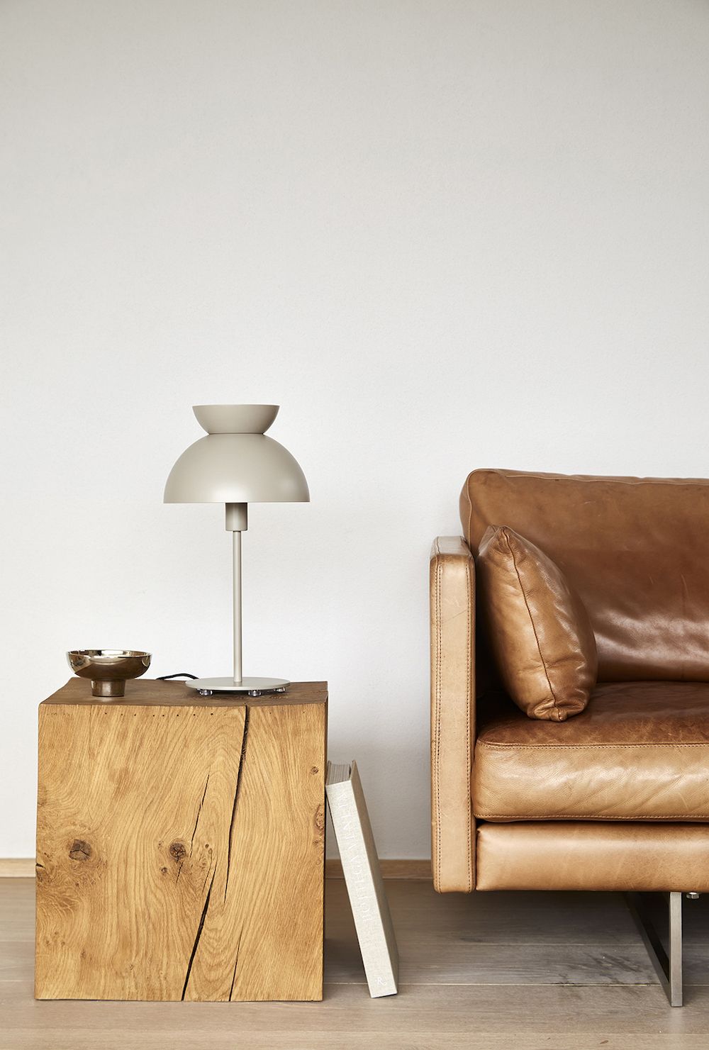 Lampa stołowa na drewnianym stoliku obok kanapy brązowej