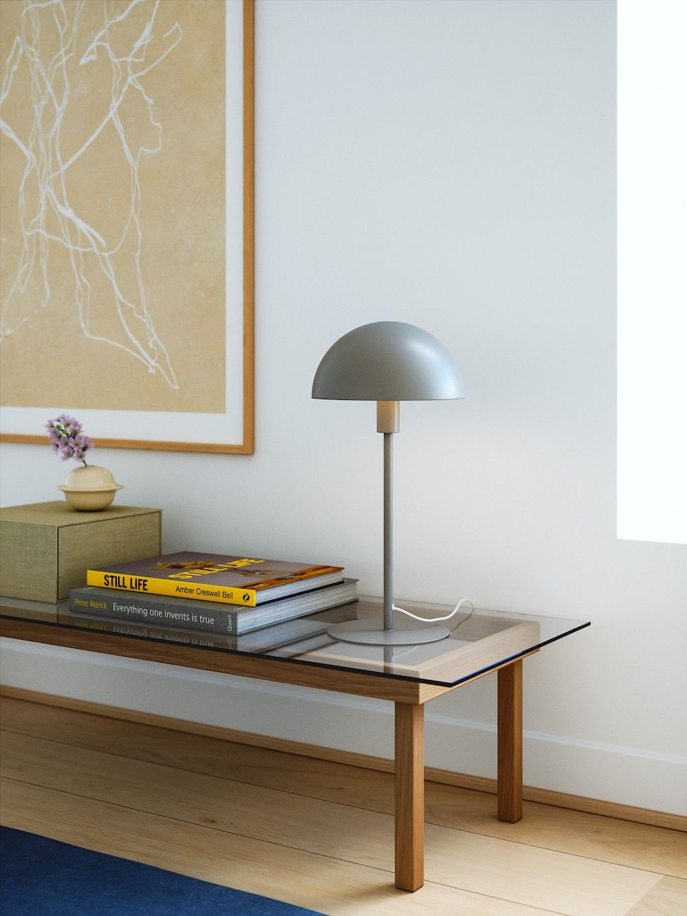 Minimalistyczna lampa stołowa na szklanym stoliku
