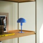 Minimalistyczna lampa w kolorze niebieskim na regale Ellen