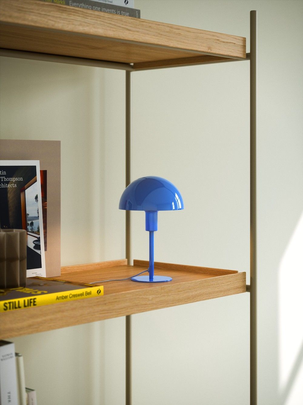 Minimalistyczna lampa w kolorze niebieskim na regale