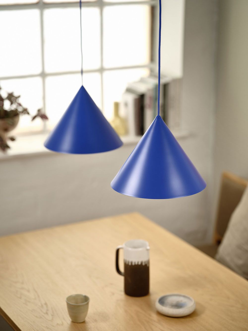 Lampa wisząca w kolorze niebieskim nad stołem