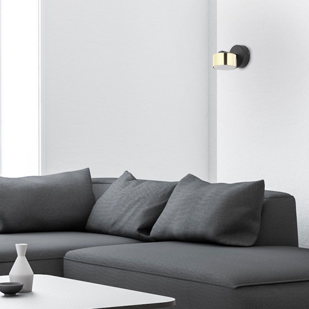 Złoty minimalistyczny kinkiet nad kanapą