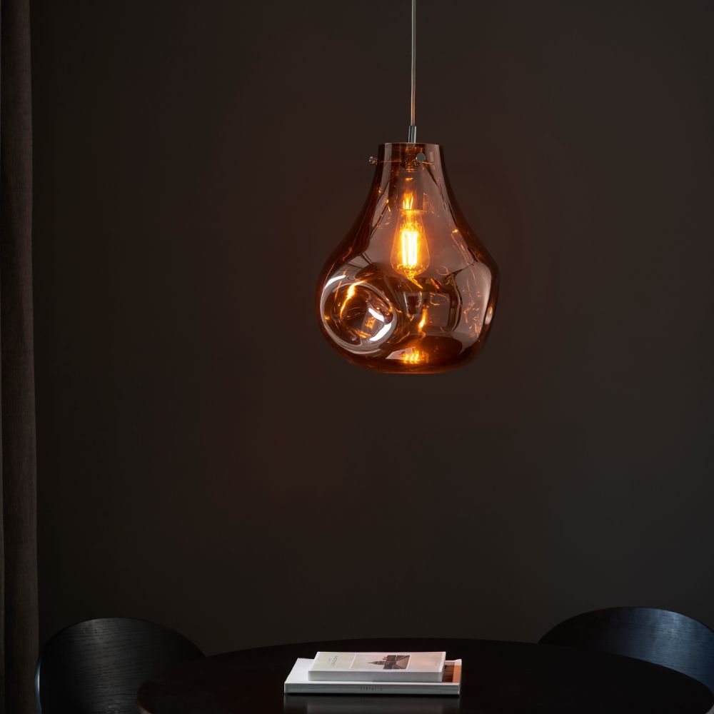 miedziana lampa wisząca nad czarnym stołem