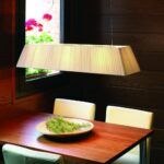 kremowa lampa wisząca nad drewniany stół