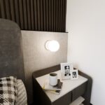 Biała lampa ścienna Bior - szklana kulka do sypialni