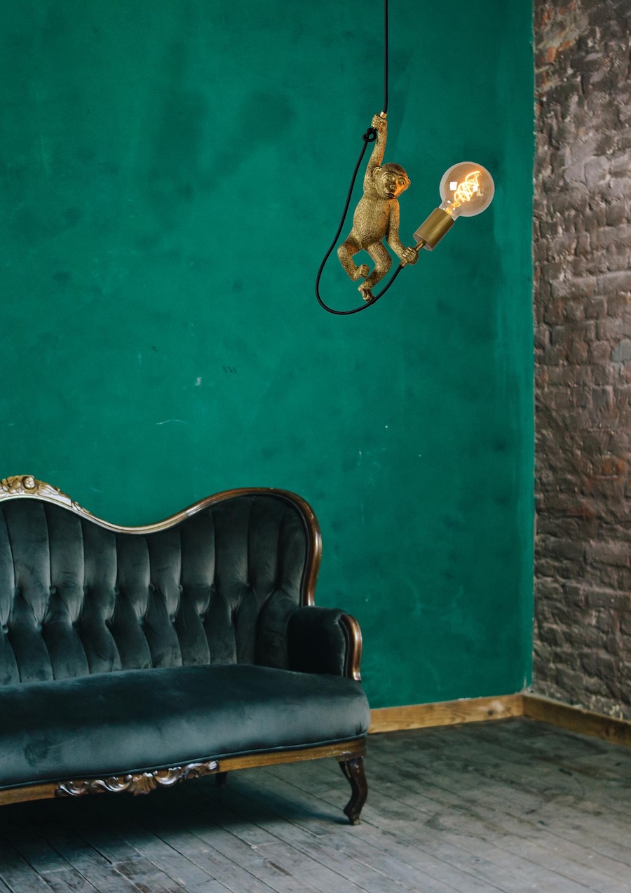 lampa wiszaca z malpa zlota w zielonym salonie