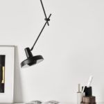czarna lampa w nowoczesnym stylu skandynawskim, czarne regulowane ramię i minimalistyczny klosz - aranżacja