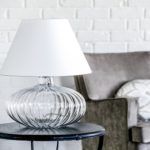 lampa stołowa w stylu modern classic. bezbarwna podstawa w kształcie spłaszczonej kuli, biały abażur