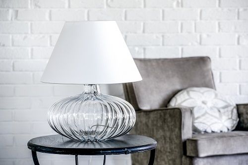 lampa stołowa w stylu modern classic. bezbarwna podstawa w kształcie spłaszczonej kuli, biały abażur