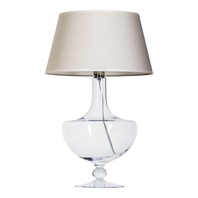 lampa stołowa ze szklaną, przezroczystą podstawą w oryginalnym kształcie i klasycznym, beżowym abażurem - aranżacja